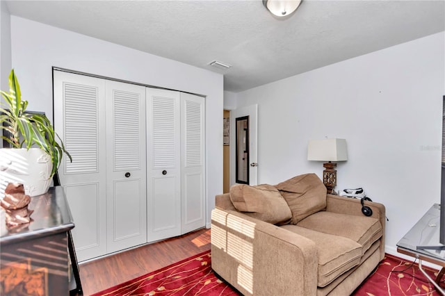 living room with a textured ceiling and hardwood / wood-style floors