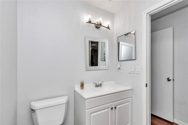 bathroom with toilet, wood-type flooring, and vanity