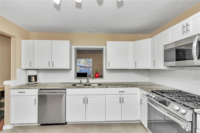 kitchen featuring sink, white cabinets, tasteful backsplash, and appliances with stainless steel finishes