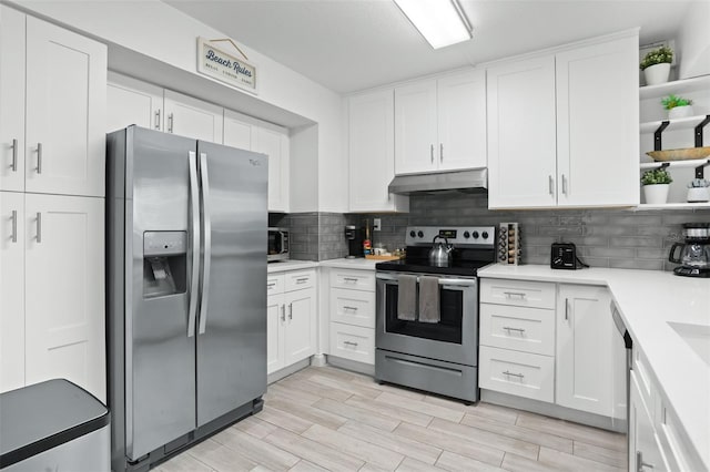 kitchen featuring stainless steel appliances, white cabinets, light wood-type flooring, and backsplash