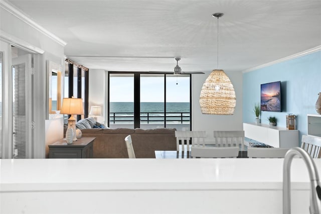 dining area featuring floor to ceiling windows, ceiling fan, crown molding, and a water view