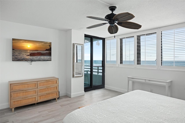 bedroom with ceiling fan, access to outside, a water view, and multiple windows