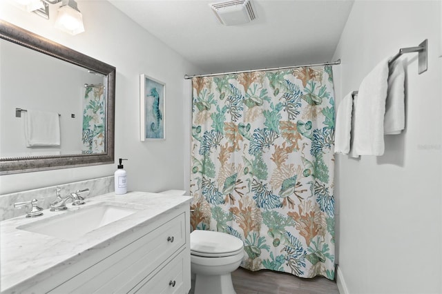 bathroom with a shower with curtain, hardwood / wood-style floors, vanity, and toilet