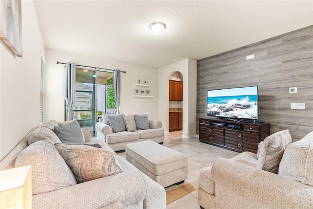 tiled living room featuring a textured ceiling