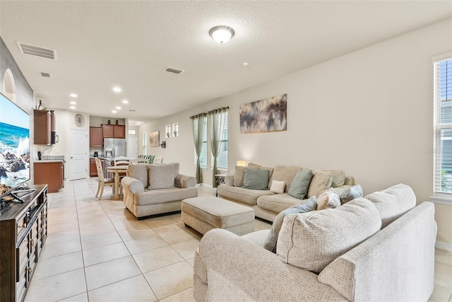 tiled living room featuring a textured ceiling and plenty of natural light