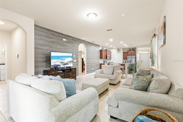 living room featuring tile walls and light tile patterned flooring