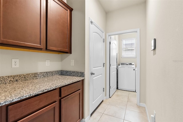 interior space with light stone countertops, washer / clothes dryer, and light tile patterned floors