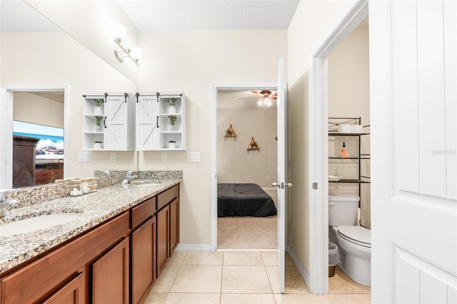 bathroom with toilet, vanity, tile patterned floors, and ceiling fan