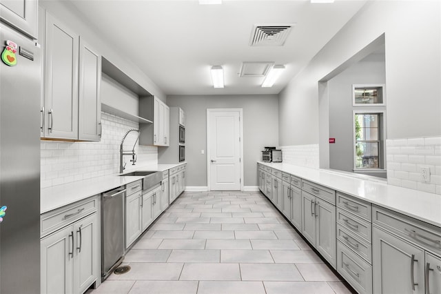 kitchen featuring stainless steel refrigerator, light tile patterned flooring, tasteful backsplash, and sink