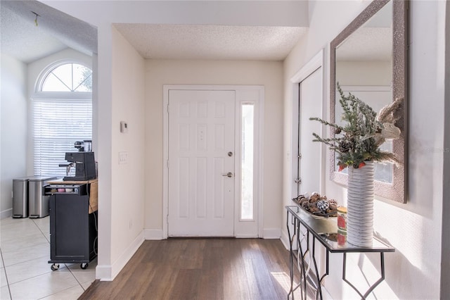 entrance foyer featuring a textured ceiling and vaulted ceiling