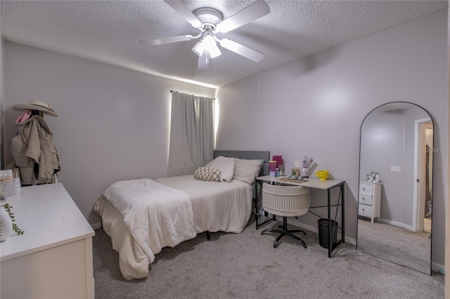 bedroom featuring a textured ceiling, ceiling fan, and light carpet