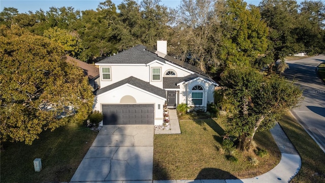 front facade with a garage and a front yard