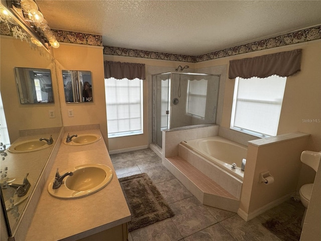 full bathroom featuring a textured ceiling, shower with separate bathtub, a wealth of natural light, and vanity