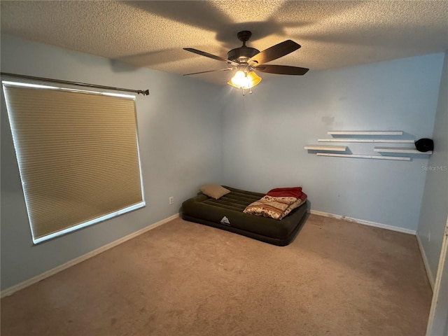 unfurnished room featuring ceiling fan, carpet, and a textured ceiling