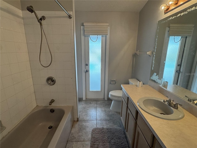 full bathroom featuring a textured ceiling, tiled shower / bath combo, vanity, and toilet