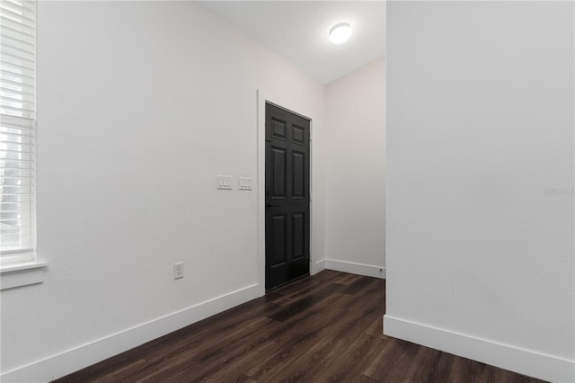 unfurnished room with dark hardwood / wood-style flooring