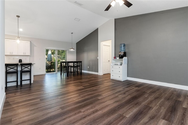 living room featuring lofted ceiling, ceiling fan, and dark wood-type flooring