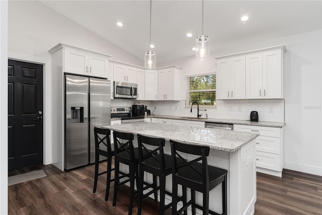 kitchen with a kitchen island, white cabinets, appliances with stainless steel finishes, and sink