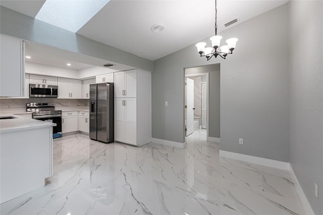 kitchen with appliances with stainless steel finishes, decorative light fixtures, white cabinetry, backsplash, and a chandelier