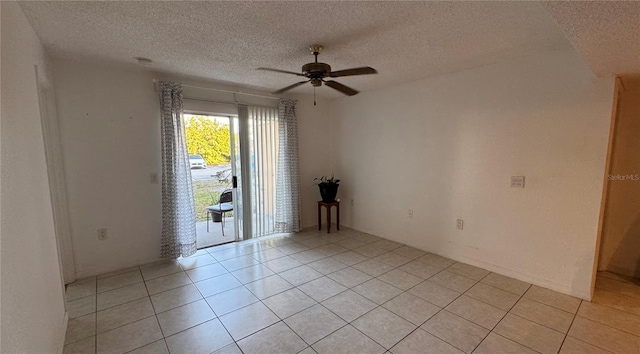 empty room with a textured ceiling, ceiling fan, and light tile patterned floors