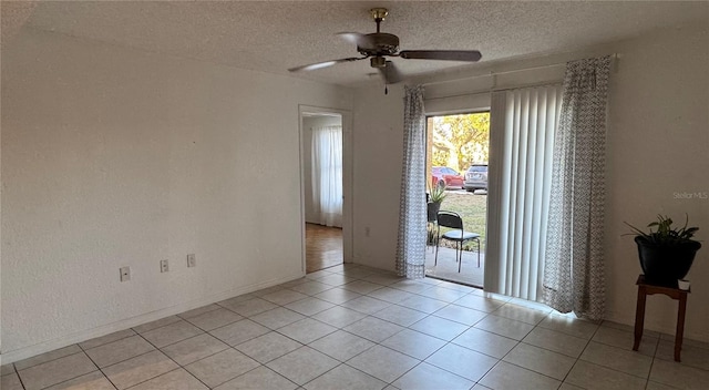 spare room with ceiling fan, a textured ceiling, and light tile patterned floors