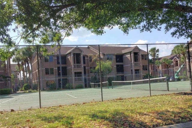 view of tennis court with a yard