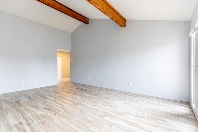 unfurnished room with vaulted ceiling with beams and light wood-type flooring