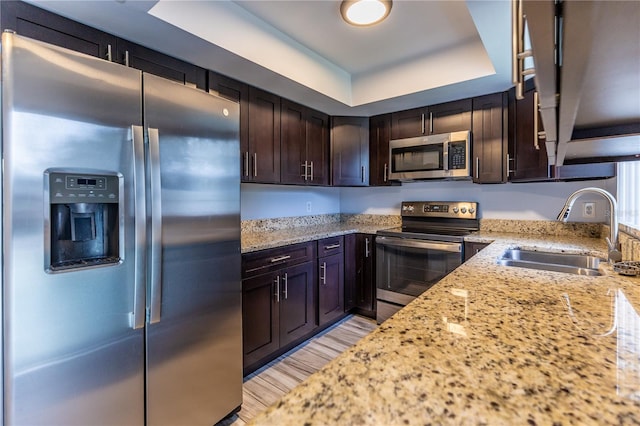 kitchen featuring light stone countertops, appliances with stainless steel finishes, and sink