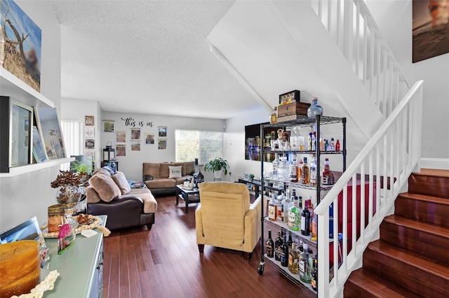 living room with indoor bar, a textured ceiling, and hardwood / wood-style floors