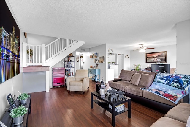 living room with dark wood-type flooring, a textured ceiling, and ceiling fan