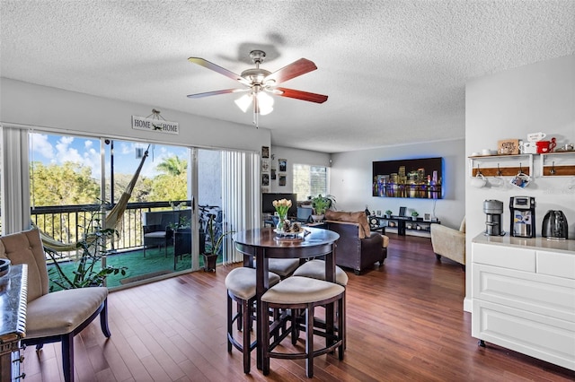 dining room with ceiling fan, dark hardwood / wood-style flooring, and a textured ceiling