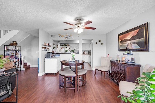 dining space with dark hardwood / wood-style flooring, a textured ceiling, and ceiling fan