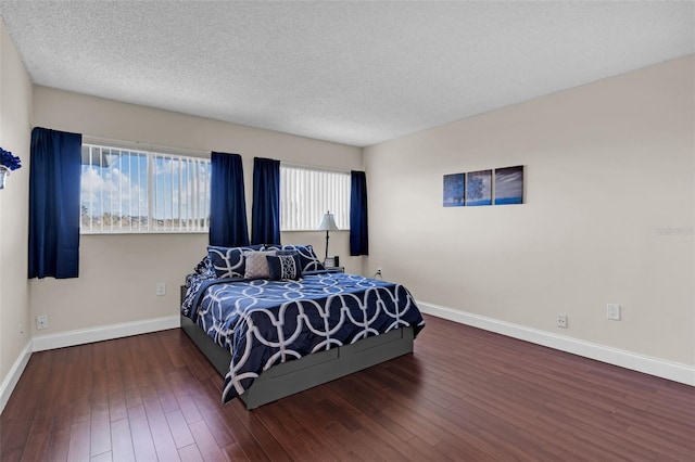 bedroom featuring dark hardwood / wood-style flooring and a textured ceiling