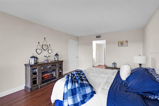 bedroom with dark hardwood / wood-style flooring and a textured ceiling