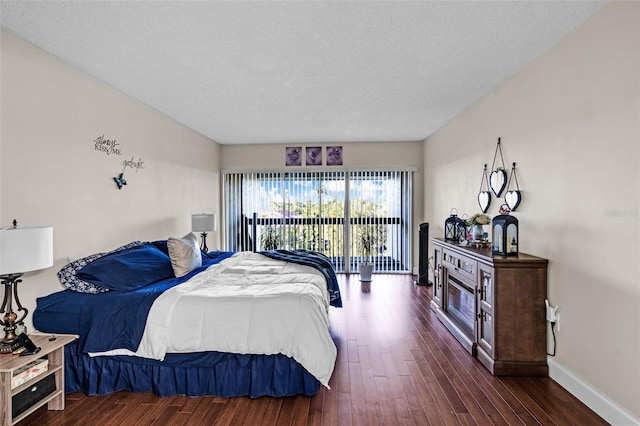 bedroom with access to exterior, a textured ceiling, and dark wood-type flooring