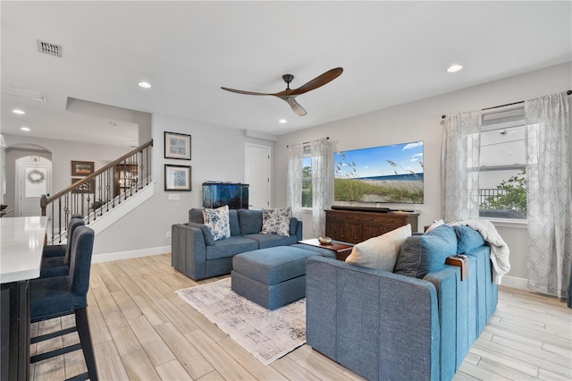 living room with ceiling fan and light hardwood / wood-style flooring