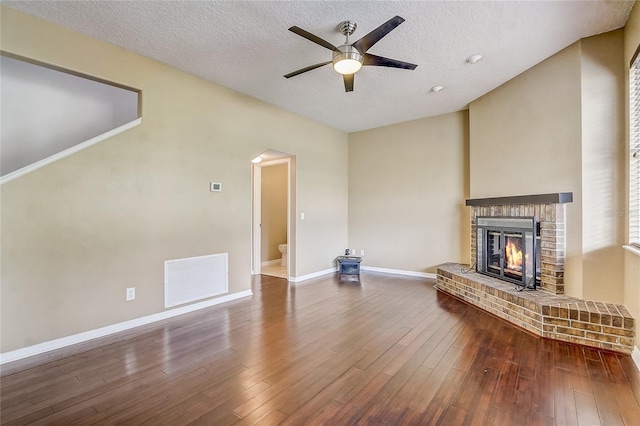 unfurnished living room featuring a textured ceiling, ceiling fan, a fireplace, and hardwood / wood-style floors