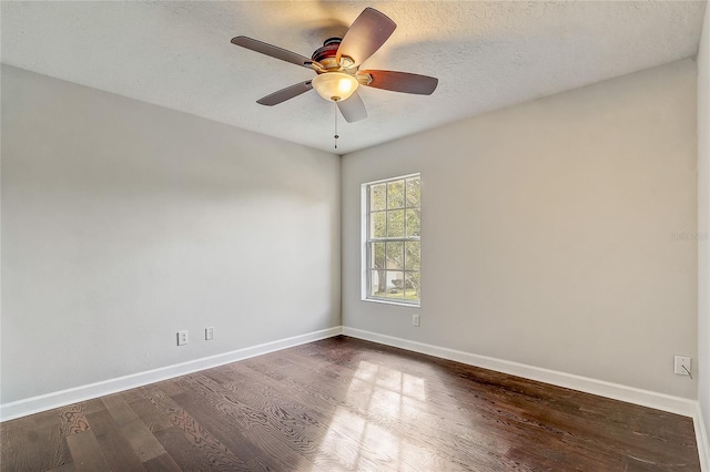 empty room with ceiling fan, dark wood-type flooring, and a textured ceiling