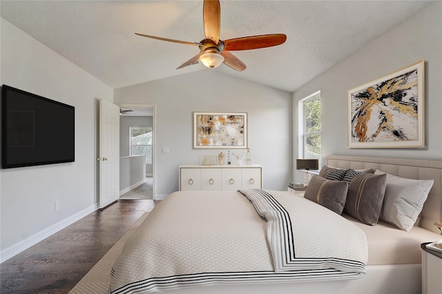 bedroom with ceiling fan, dark hardwood / wood-style flooring, multiple windows, and lofted ceiling