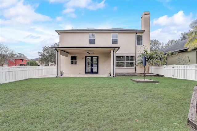 rear view of house with ceiling fan, a patio, and a yard