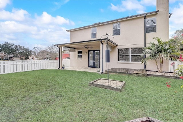 rear view of property featuring ceiling fan, a lawn, and a patio