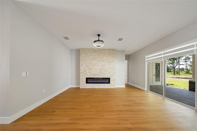 unfurnished living room with light wood-type flooring and a fireplace