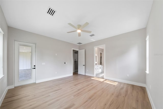 unfurnished bedroom with light wood-type flooring, ceiling fan, and ensuite bathroom