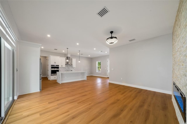 unfurnished living room featuring light hardwood / wood-style flooring and a fireplace