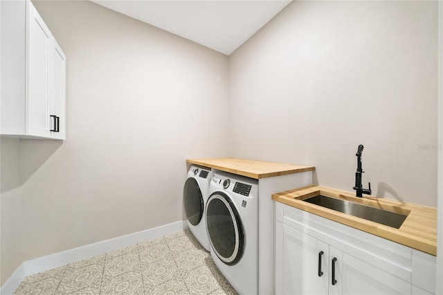 clothes washing area featuring cabinets, sink, light tile patterned flooring, and washing machine and clothes dryer