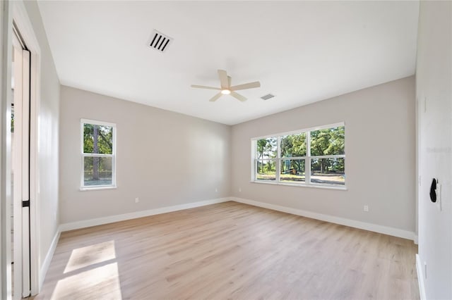 empty room with visible vents, plenty of natural light, and light wood finished floors