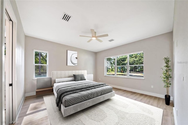 bedroom featuring light wood-type flooring, multiple windows, and visible vents