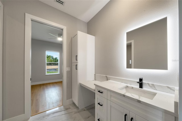 bathroom featuring marble finish floor, vanity, visible vents, and baseboards