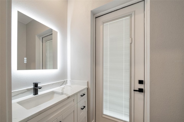 bathroom featuring a textured wall and vanity