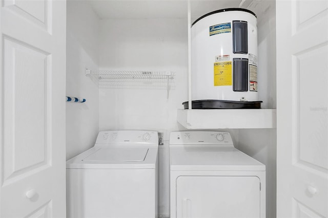 laundry area with laundry area, washing machine and dryer, and electric water heater